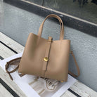 Beige handbag with gold accents on a surface with a blurred background