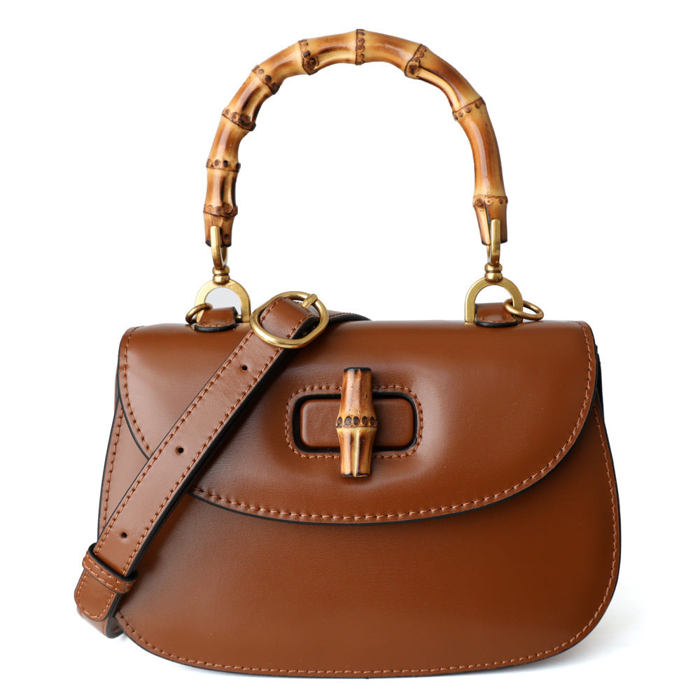 Brown leather handbag with bamboo handle on a white background