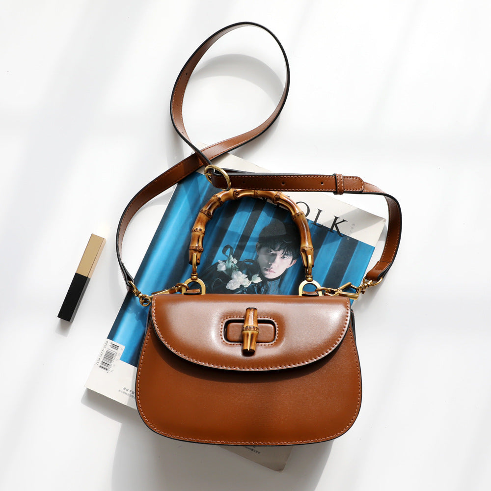 Brown handbag with wooden handle on top of a magazine