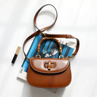 Brown handbag with wooden handle on top of a magazine