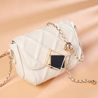 White handbag with gold chain strap on a beige background