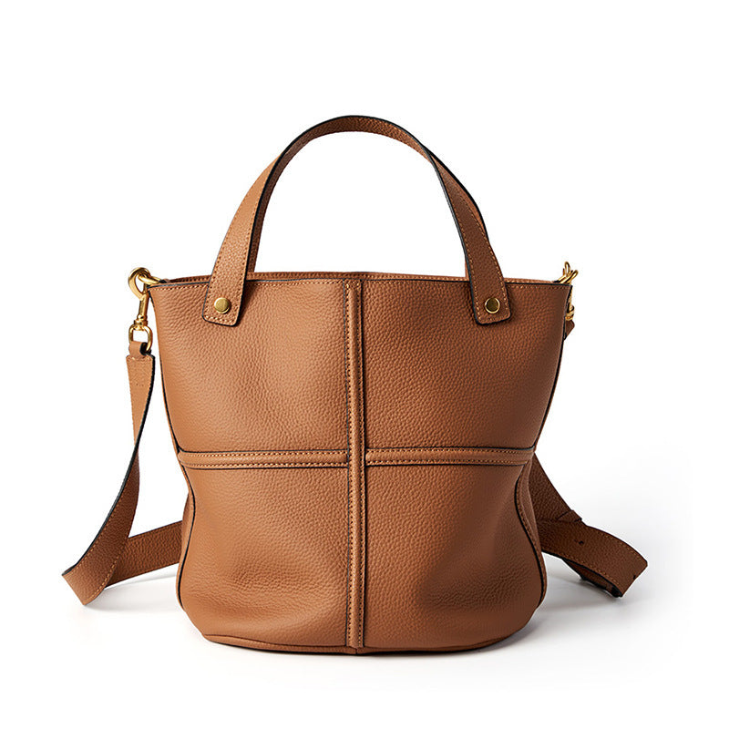 Brown leather handbag with a shoulder strap on a white background