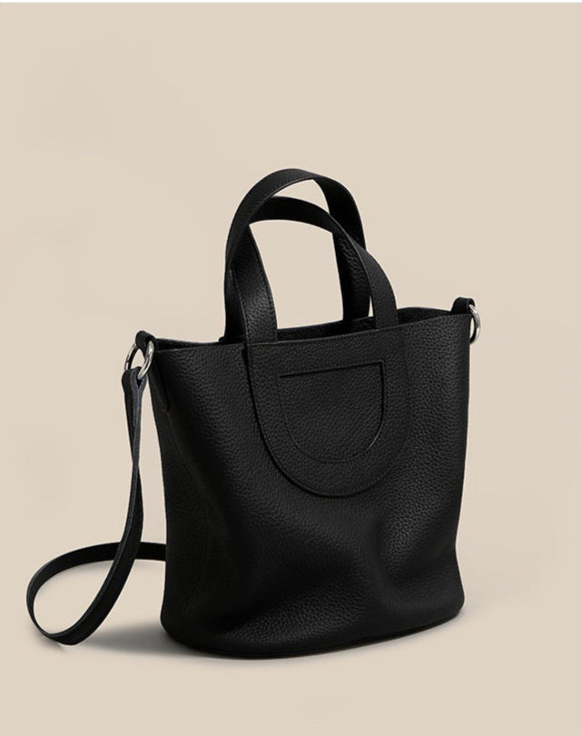 Black handbag on a beige background