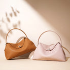 Two handbags, one brown and one pink, on a beige background.