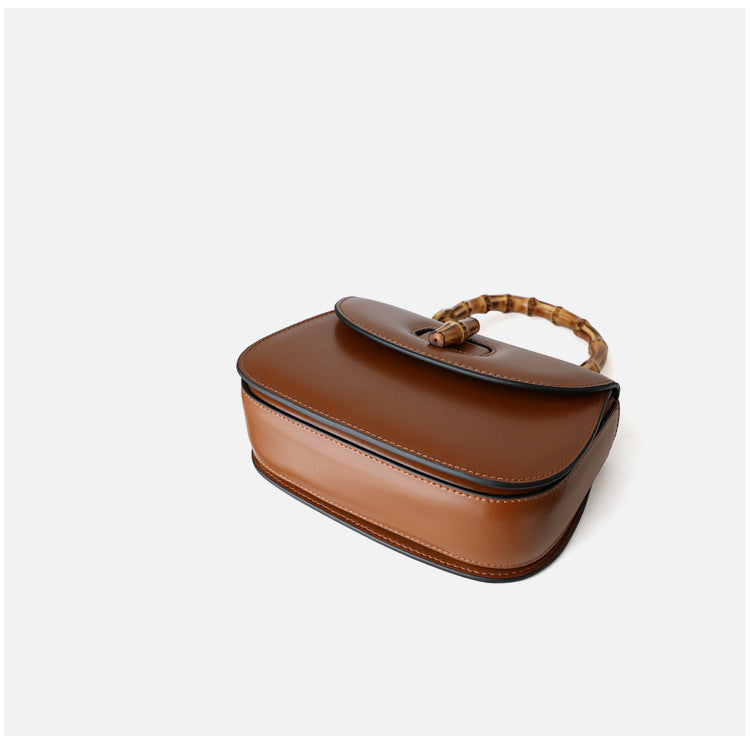 Brown handbag with a bamboo handle on a white background