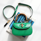 Green handbag with wooden handle on top of a magazine