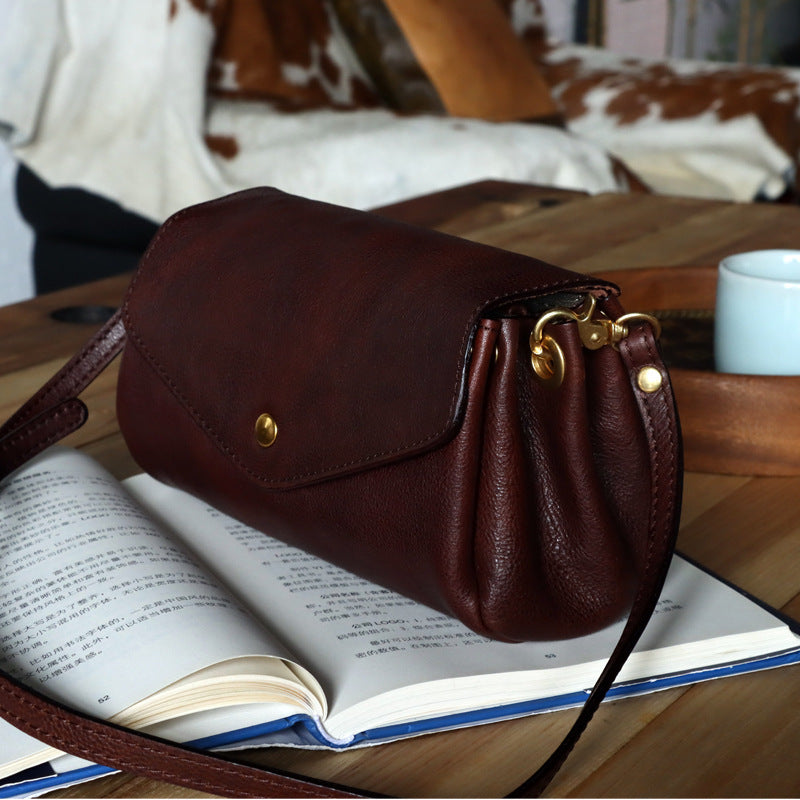 Brown leather handbag on an open book with a blurred background