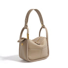 Beige handbag with gold accents on a white background