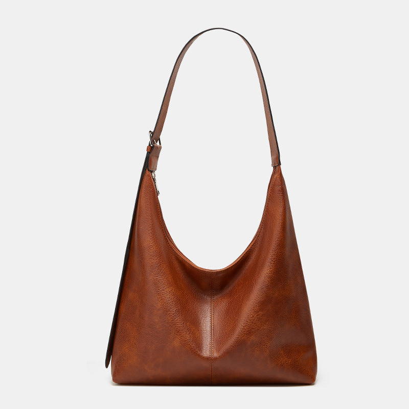 Brown leather handbag on a light gray background