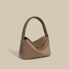 Brown handbag with braided handle on a beige background