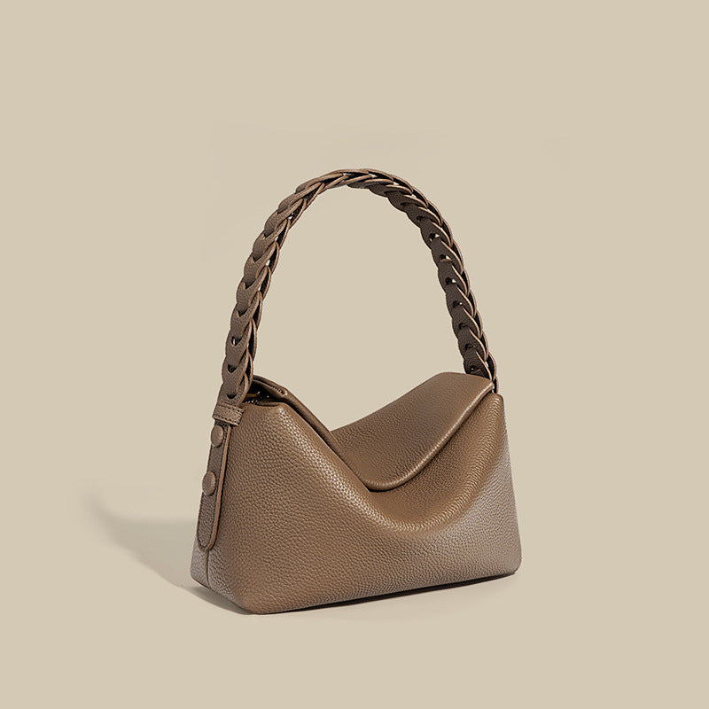 Brown handbag with braided handle on a beige background