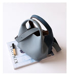 Gray handbag on a magazine with a white background
