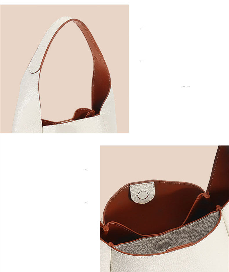 Close-up of a handbag with brown interior and beige exterior, featuring a shoulder strap.