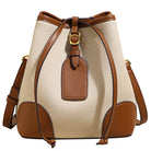 Beige and brown leather bucket bag with a tag on a white background