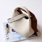 Beige handbag with brown accents on a magazine