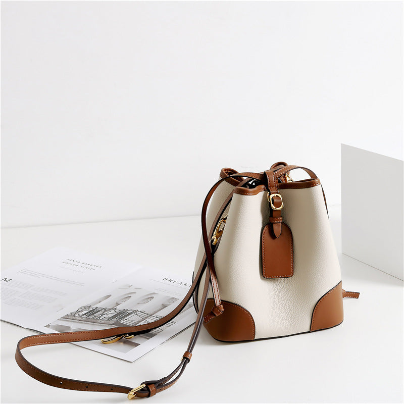 White and brown handbag on a white surface with a light gray background