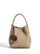 Beige handbag with a brown tag on a white background