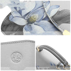 Gray handbag with floral design and brand logo, close-up of handle and fabric texture.