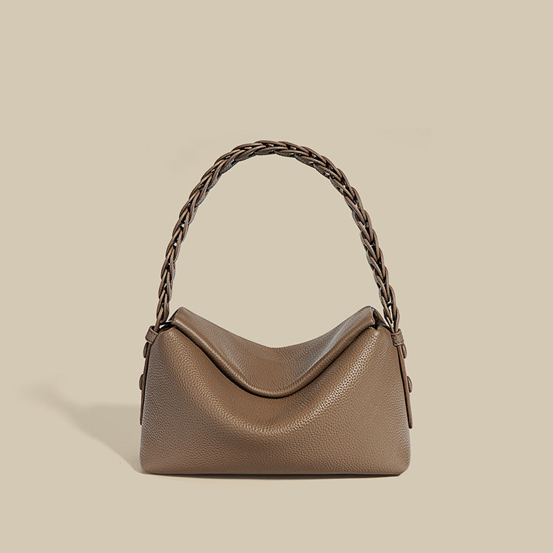 Brown handbag with braided handle on beige background