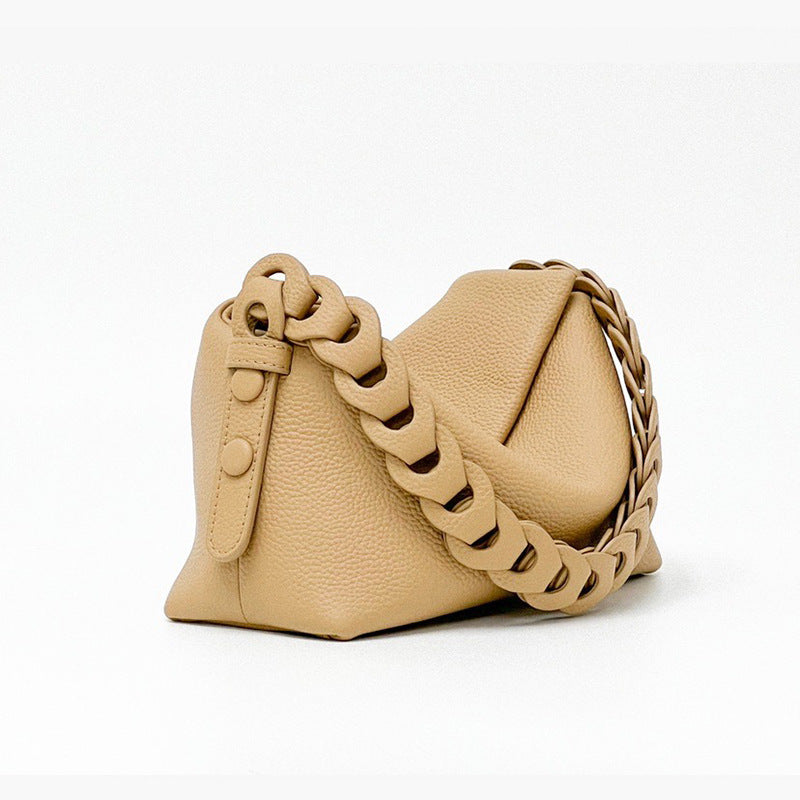 Beige handbag with braided chain strap on a white background