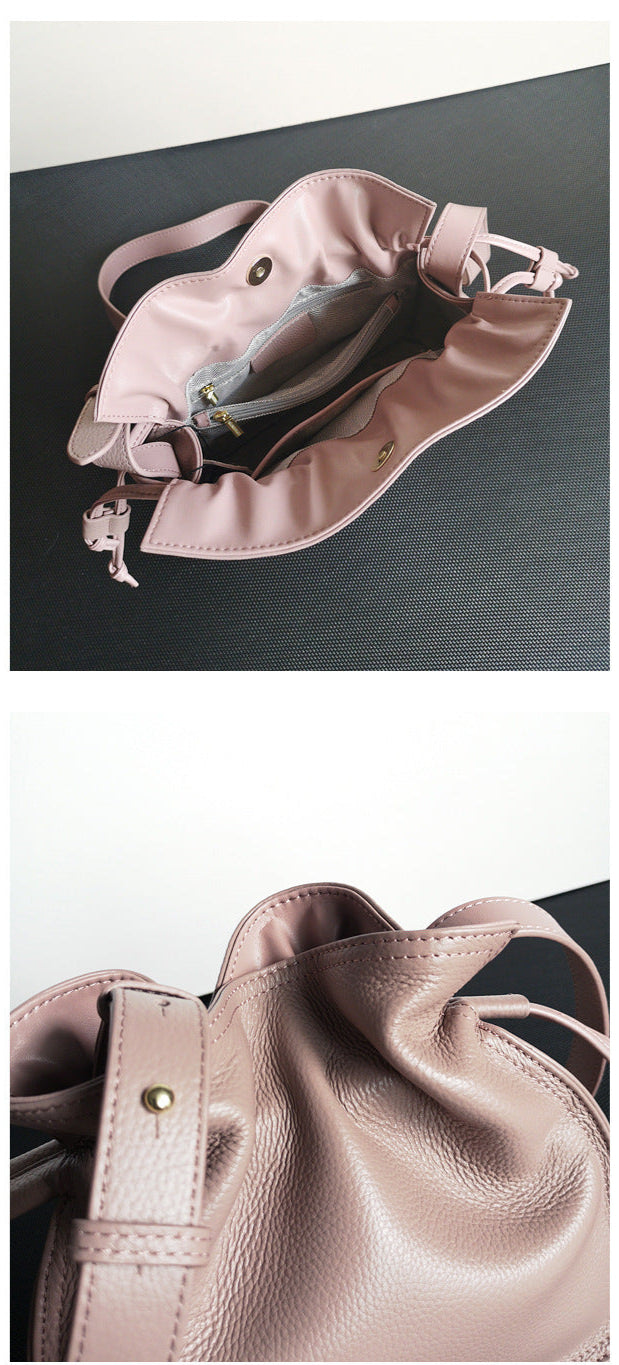 Pink handbag with a strap on a dark surface