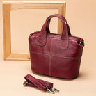 Red handbag with detachable strap on a beige background
