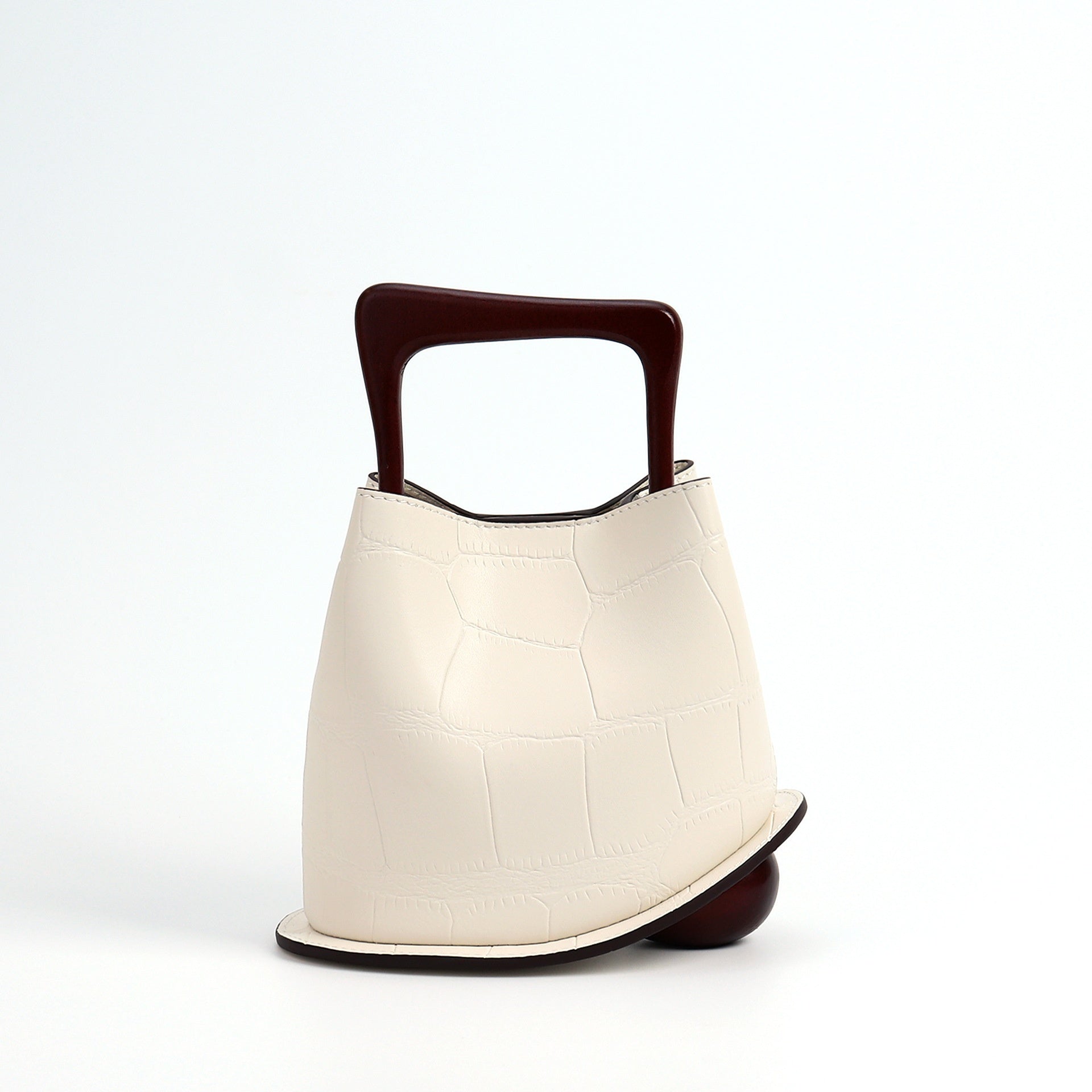 White handbag with a brown handle on a white background