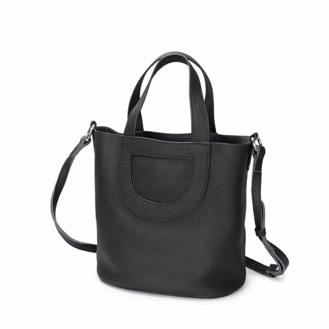 Black handbag with a shoulder strap on a white background
