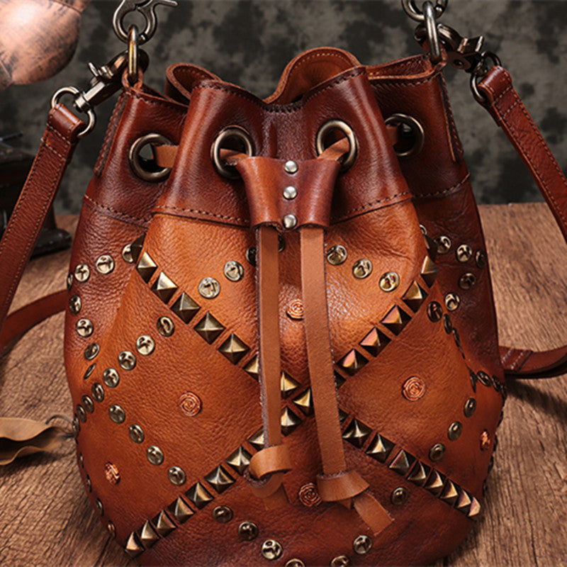 Brown leather bag with studs on a wooden surface