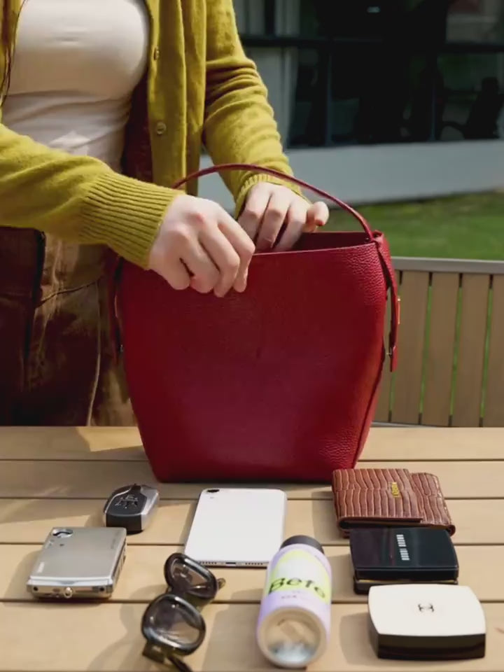 Video of wine red handbag with a strap on a white background