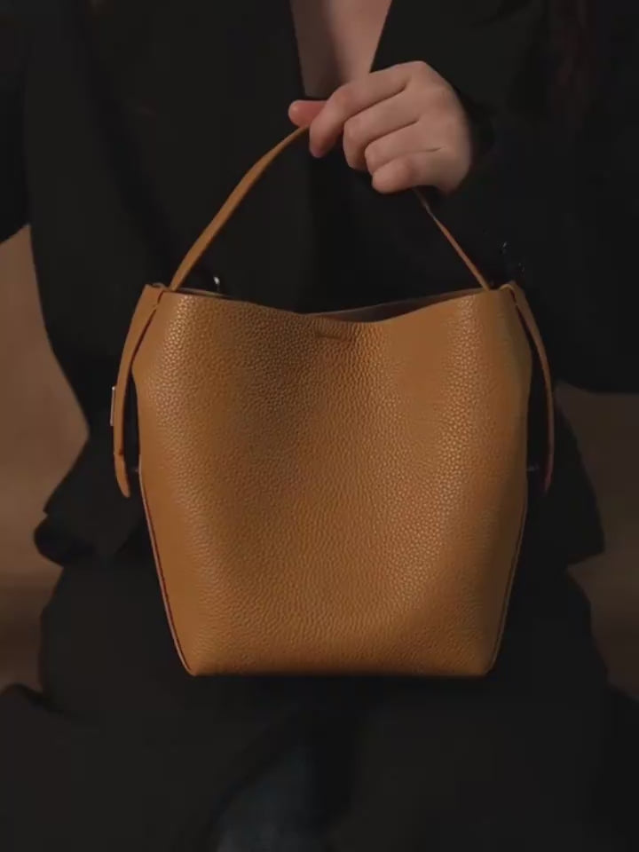 Video of brown handbag with a strap on a white background