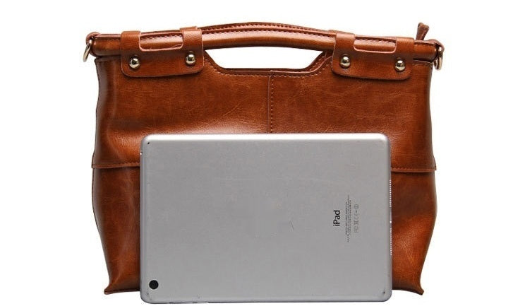 Brown leather briefcase with a silver tablet on a white background