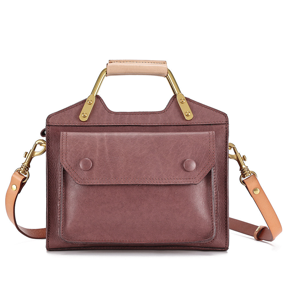 Brown leather handbag with gold accents on a white background