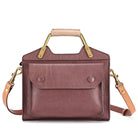 Brown leather handbag with gold accents on a white background