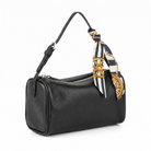 A black pebbled leather shoulder bag with a top zipper, featuring a navy blue and cream silk scarf with gold nautical ship wheel patterns tied to the strap, shown on a white background.