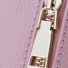Close-up of a pink textured surface with a gold zipper and pull.