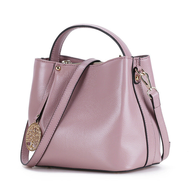 Pink handbag with a shoulder strap on a white background