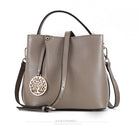 Gray handbag with a decorative pendant on a white background