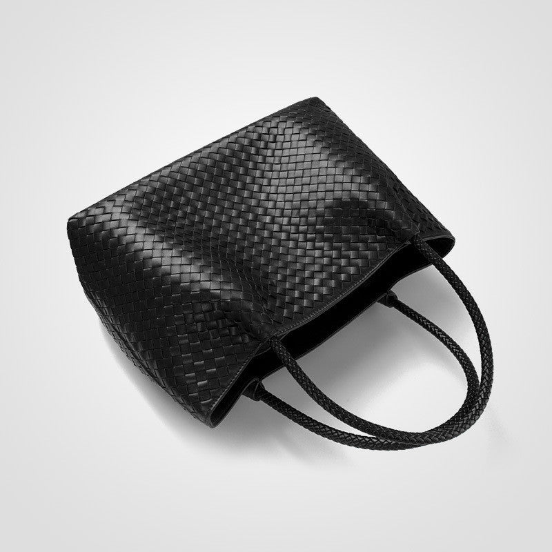 Black woven handbag on a light gray background
