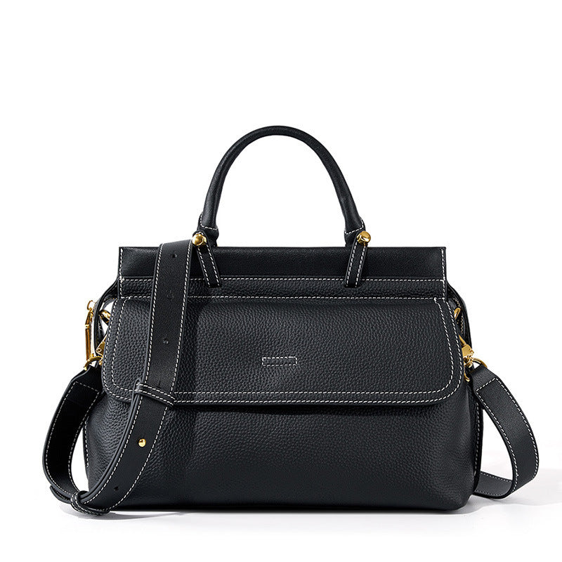 Black handbag with gold accents on a white background