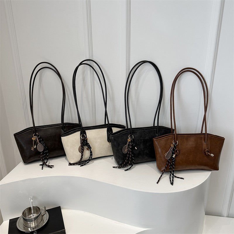 Four handbags in black, beige, and brown on a white surface with a light gray background.