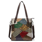 Multicolored patchwork handbag with brown leather straps on a white background