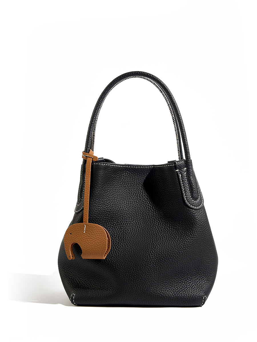 Black handbag with a brown tag featuring an elephant emblem on a white background