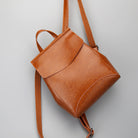Brown leather backpack on a light gray background
