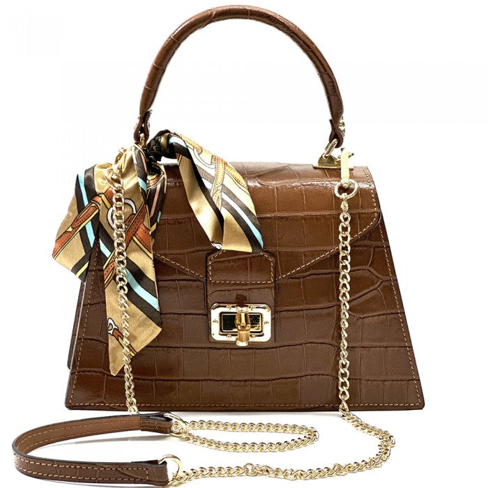 Brown crocodile-patterned handbag with gold chain and scarf on a white background