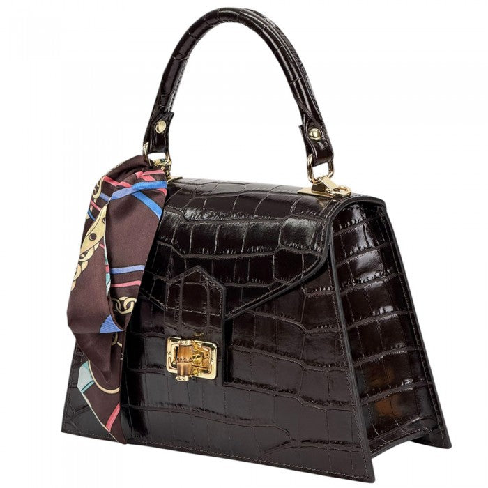 Black crocodile-patterned handbag with a gold clasp and a colorful scarf on a white background