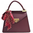 Maroon handbag with gold accents and a red scarf on a white background