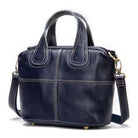 Black leather handbag with a shoulder strap on a white background