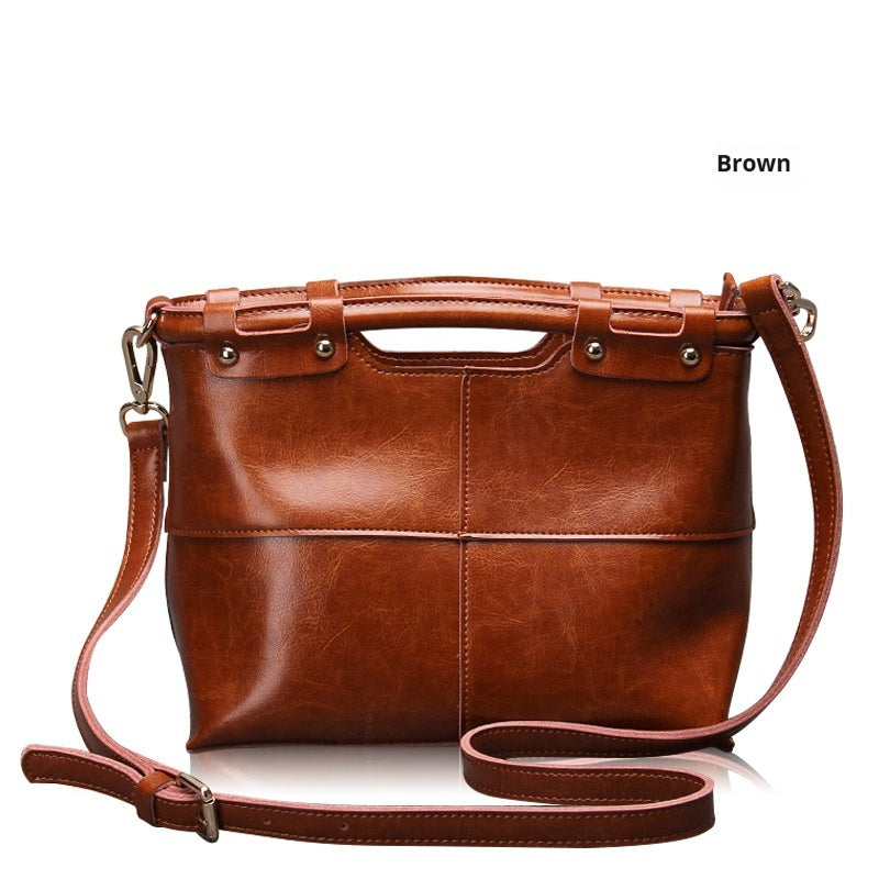 Brown leather handbag with a strap on a white background