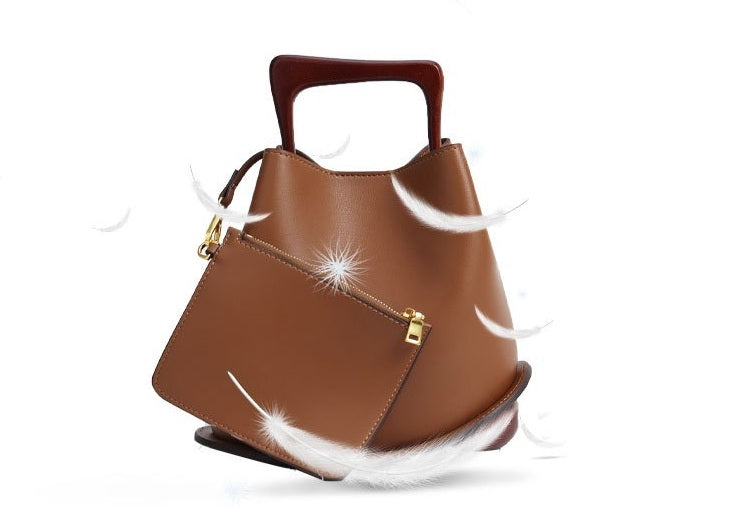 Brown handbag with feathers on a white background